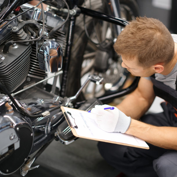 Motorcycle owner looking over motorcycle parts.